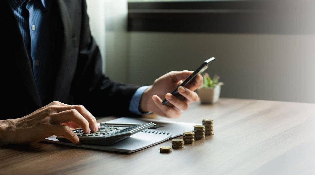 pessoa realizando cálculos, representando como funciona o crédito imobiliário