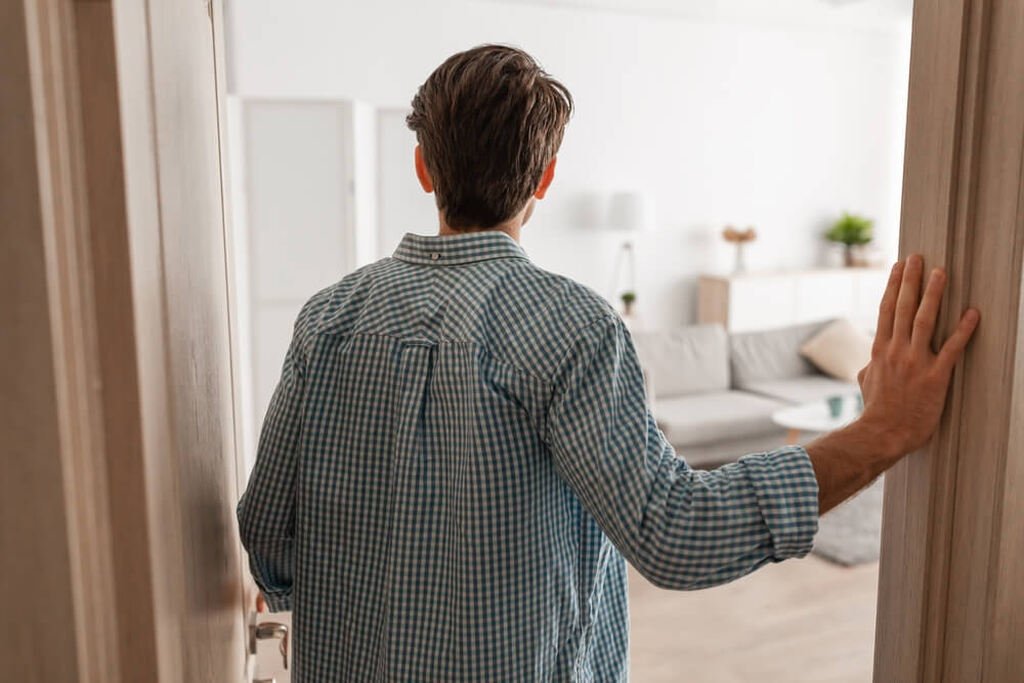 homem entrando em sua casa após fazer financiamento de imóveis