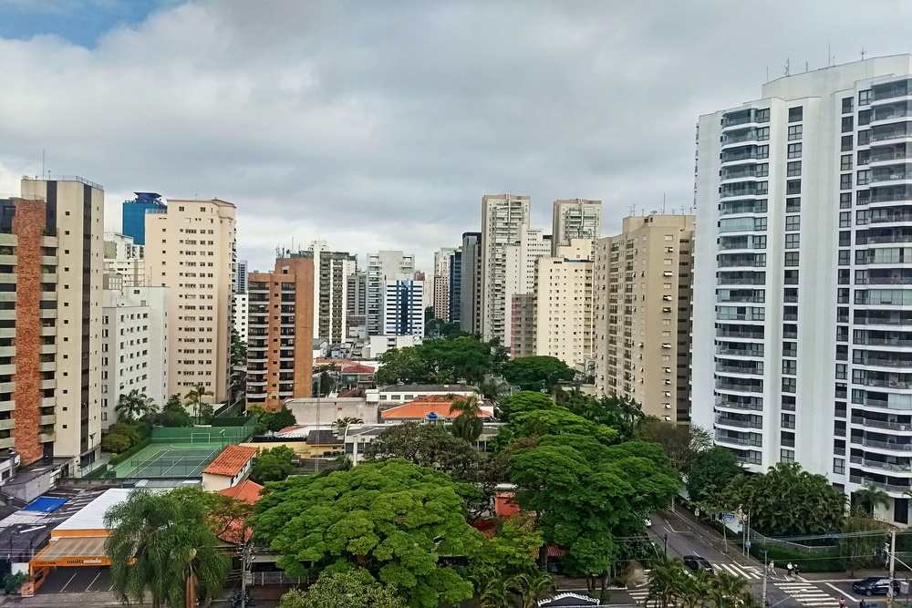 Prédios em volta com alguns comércios ao meio em Moema