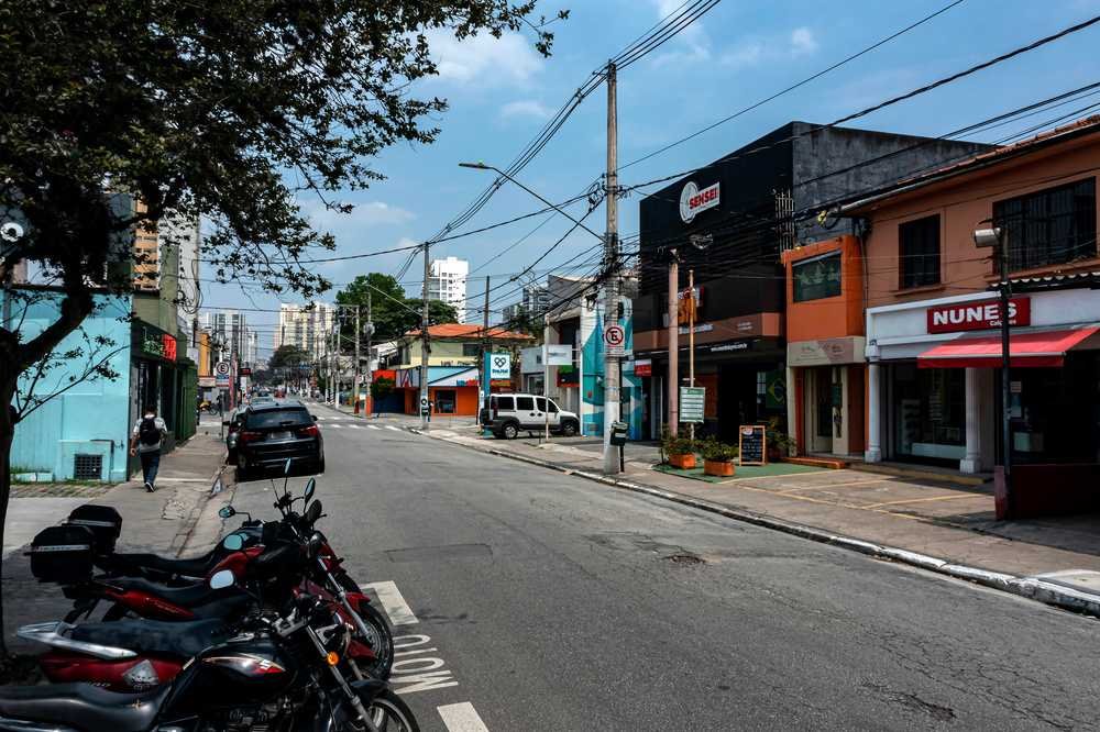 rua em brooklin sp, com comércios, motos e carros