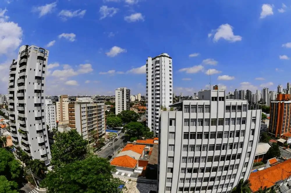 Imagem de uma paisagem urbana com vários prédios altos e céu azul com nuvens, representando Campo Belo, em São Paulo.